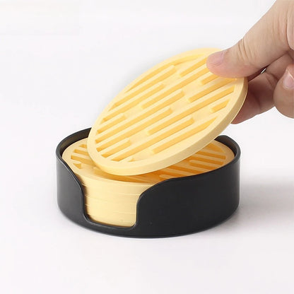 Hand holding a yellow grill over a black container on a white background