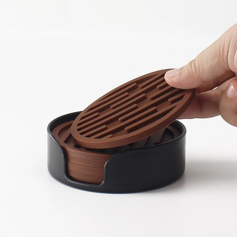Hand holding a brown grill-like object over a black container on a white background