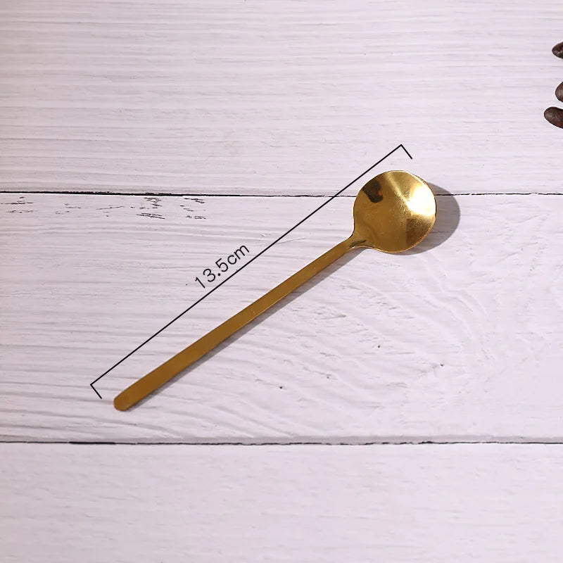Gold spoon on a white wooden surface with measurement label
