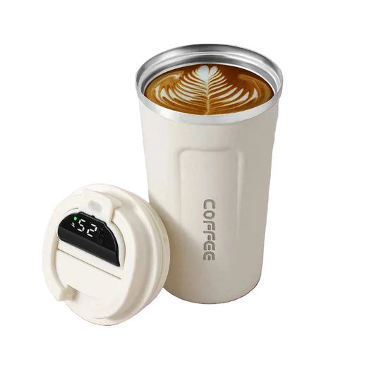 White insulated coffee tumbler with a digital temperature display on a pink surface with coffee beans.