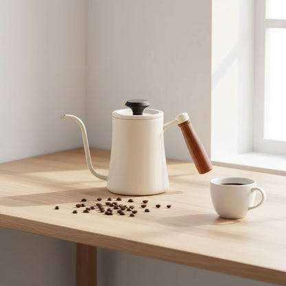 An off-white gooseneck coffee kettle with a brown wood-grain handle, a black lid knob, and an included digital temperature gauge, on a Scandinavian-style workspace desk, soft warm daylight, coffee beans and coffee cup
