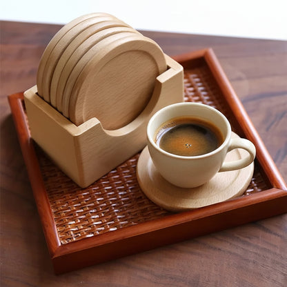 Set of wooden coasters with a holder on a woven tray, accompanied by a coffee cup