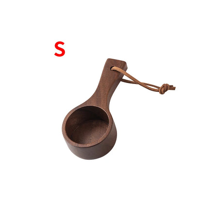 Brown wooden scoop with leather handle on a white background